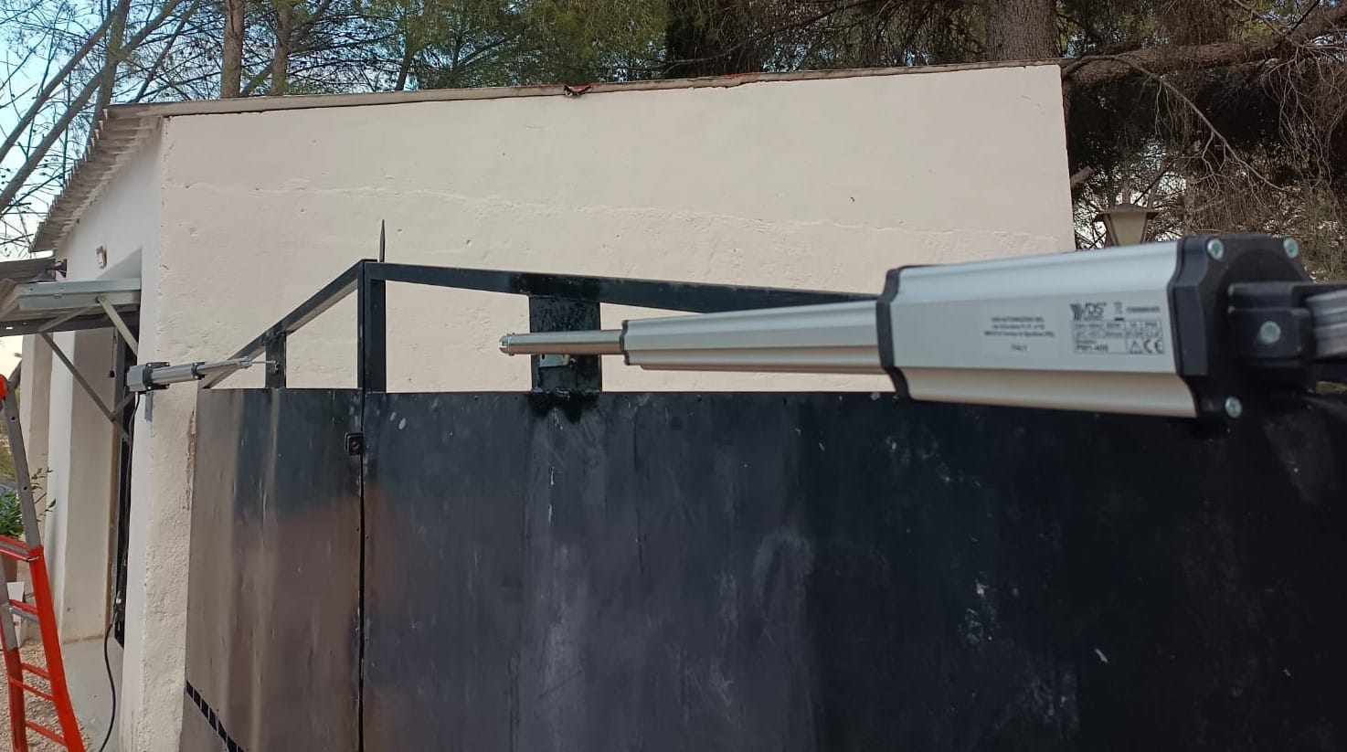 Motor automático para puerta abatible metálica en acceso residencial
