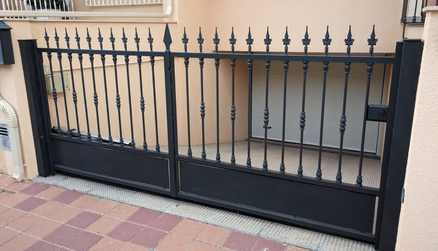 Puerta abatible de doble hoja en hierro forjado y macizo con automatismo